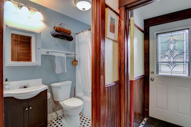 full bath featuring toilet, shower / tub combo, baseboards, and vanity