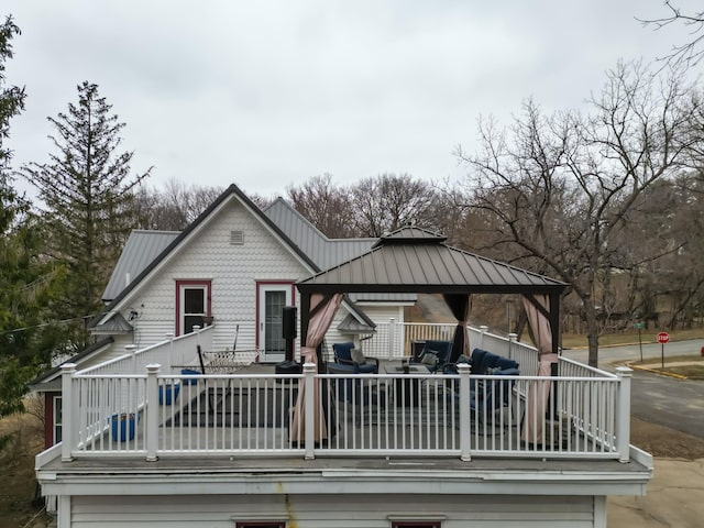 back of house with an outdoor hangout area, a gazebo, metal roof, and a balcony