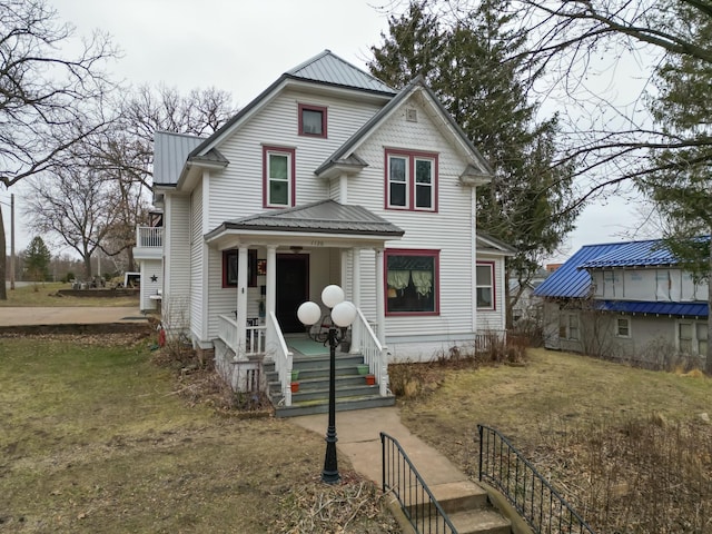 victorian house with covered porch and metal roof