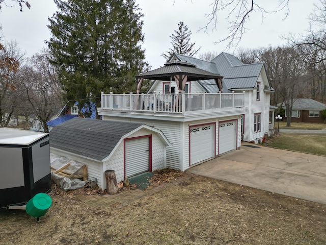 exterior space with driveway, an outdoor structure, a garage, a gazebo, and a storage unit