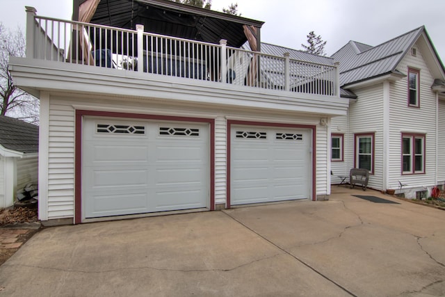 view of front of property featuring driveway, a garage, and a balcony