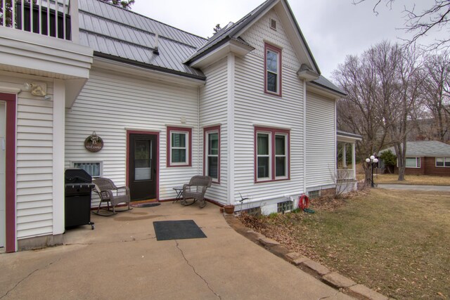 rear view of house with metal roof, a patio area, and a balcony