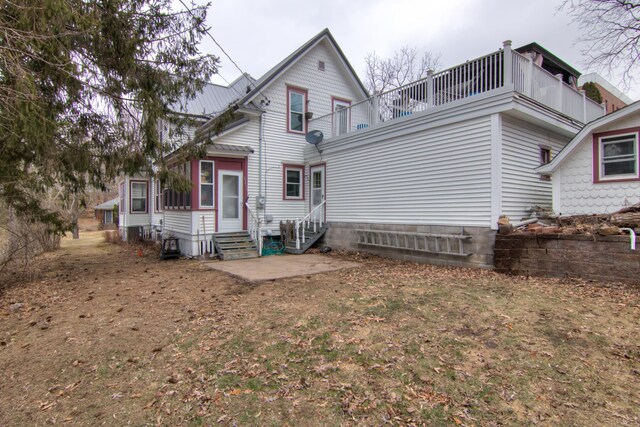 back of house with entry steps and a balcony