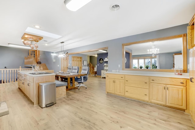 108 1st St, Kenyon, MN 55946 - kitchen with light brown cabinetry, light wood-style floors, a chandelier, decorative light fixtures, and light countertops