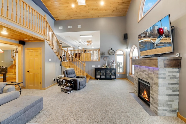 108 1st St, Kenyon, MN 55946 - carpeted living area with stairs, baseboards, a high ceiling, a stone fireplace, and wood ceiling