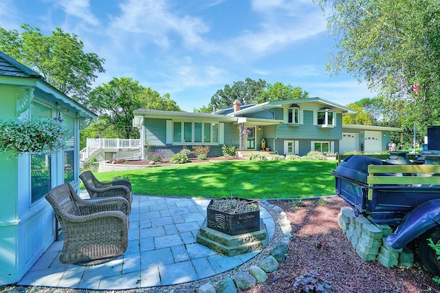108 1st St, Kenyon, MN 55946 - back of property featuring a lawn, a chimney, a wooden deck, and a patio area