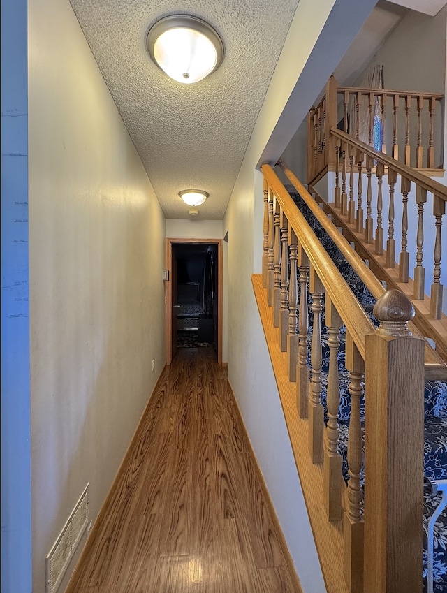 14132 Heywood Path, Apple Valley, MN 55124 - corridor with visible vents, stairway, wood finished floors, and a textured ceiling