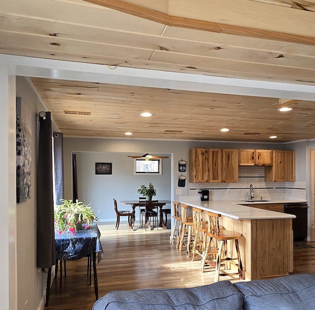 22004 Old Curry Rd SE, Cass Lake, MN 56633 - kitchen featuring a sink, a breakfast bar, a peninsula, wood finished floors, and light countertops
