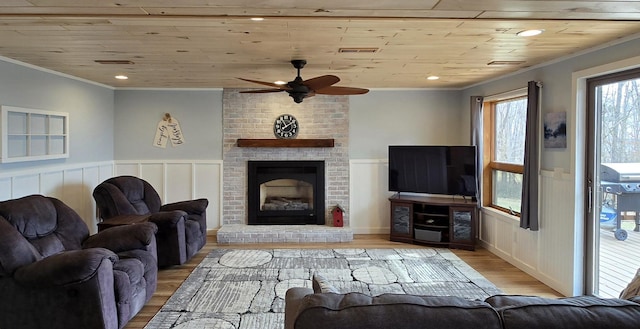 22004 Old Curry Rd SE, Cass Lake, MN 56633 - living room featuring crown molding, wainscoting, ceiling fan, wood finished floors, and a fireplace