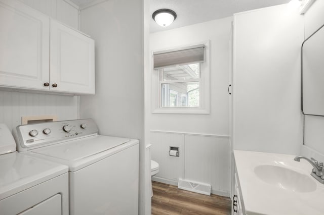 11799 191st Ave NW, Elk River, MN 55330 - laundry room with separate washer and dryer, wood finished floors, and a wainscoted wall