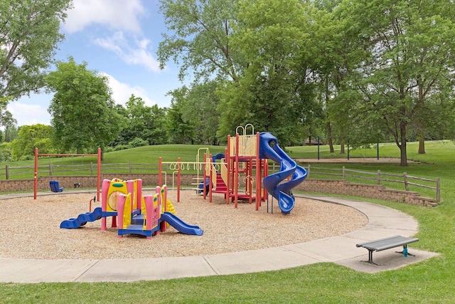community play area featuring a lawn and fence