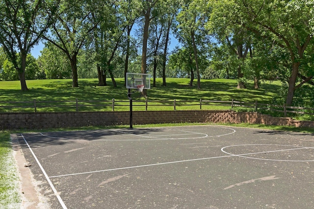 view of sport court featuring a lawn, fence, and community basketball court