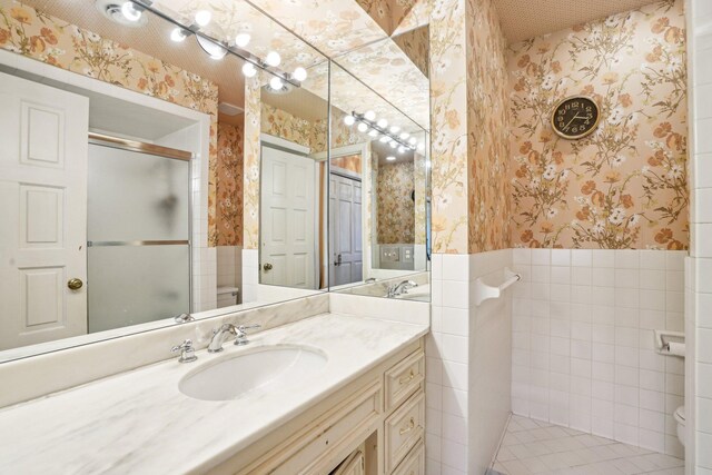 8621 Basswood Rd Unit 32, Eden Prairie, MN 55344 - bathroom featuring toilet, a shower stall, vanity, wallpapered walls, and a wainscoted wall
