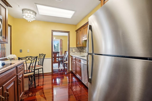 8621 Basswood Rd Unit 32, Eden Prairie, MN 55344 - kitchen with a notable chandelier, dark wood-style flooring, stainless steel appliances, decorative backsplash, and light stone counters