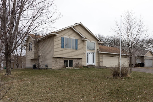 split level home featuring central AC, driveway, an attached garage, and a front lawn