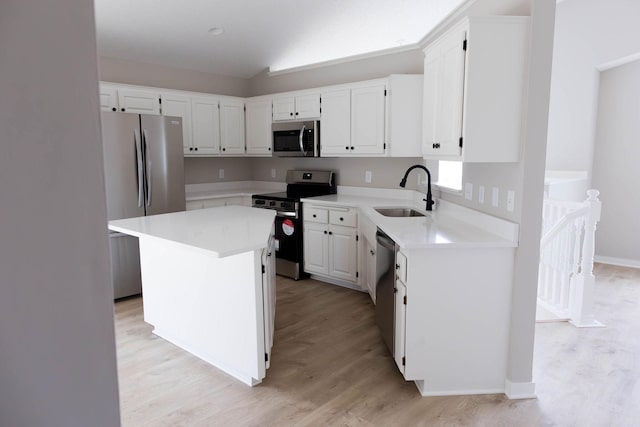 kitchen featuring stainless steel appliances, light wood-style flooring, white cabinetry, and a sink