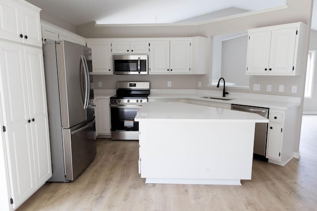 kitchen with stainless steel appliances, light wood-style flooring, white cabinetry, and a sink