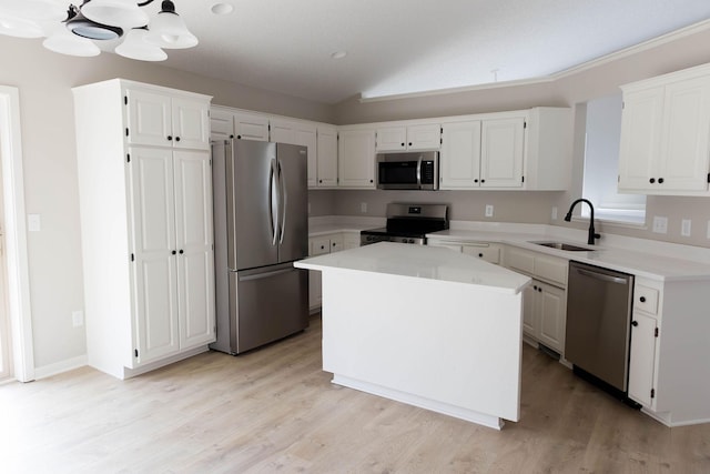 kitchen featuring light countertops, vaulted ceiling, a sink, and appliances with stainless steel finishes