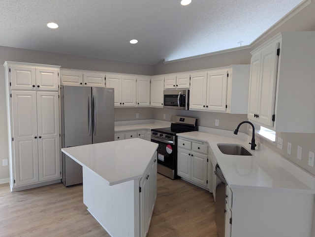 kitchen featuring light wood-style floors, white cabinets, appliances with stainless steel finishes, light countertops, and a sink