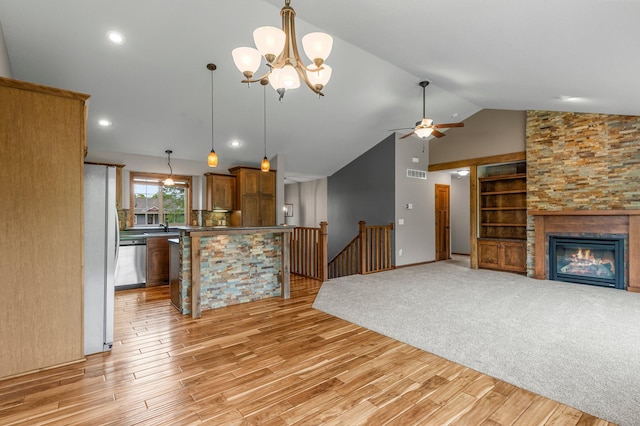 6387 203rd Ct N, Forest Lake, MN 55025 - unfurnished living room featuring light wood-type flooring, a chandelier, ceiling fan, lofted ceiling, and a large fireplace
