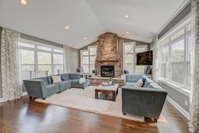 living area featuring recessed lighting, vaulted ceiling, a stone fireplace, and dark wood finished floors