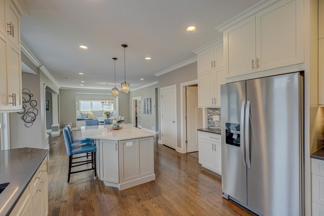 kitchen featuring a center island, dark wood finished floors, stainless steel fridge with ice dispenser, an inviting chandelier, and recessed lighting