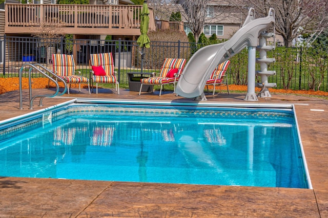 outdoor pool featuring a patio, a water slide, and fence