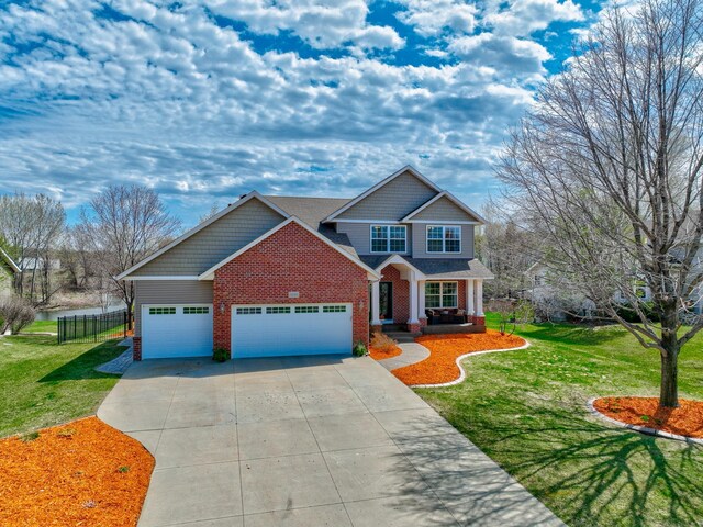 craftsman-style house with fence, concrete driveway, a front lawn, and brick siding