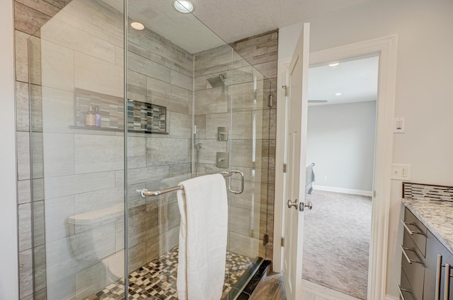 bathroom with vanity, recessed lighting, baseboards, and a stall shower