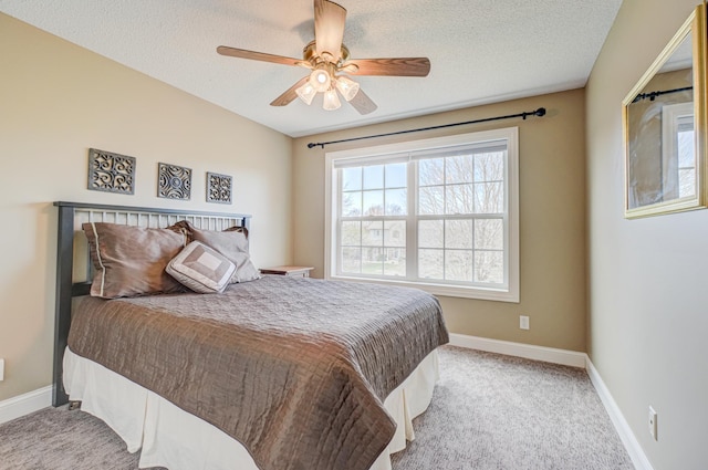 bedroom with baseboards, a textured ceiling, carpet, and ceiling fan