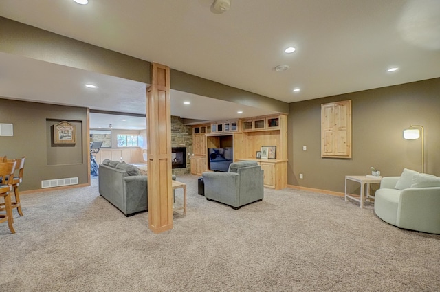 living room featuring visible vents, baseboards, light carpet, and a stone fireplace
