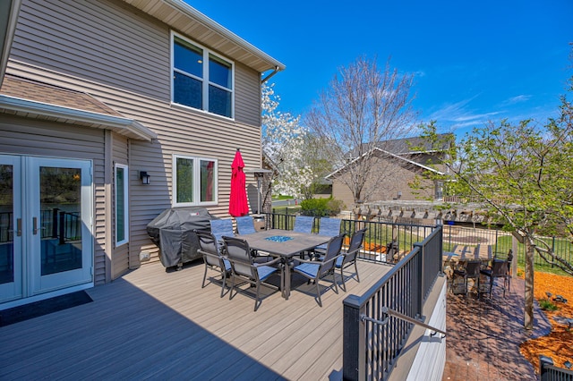 wooden terrace featuring outdoor dining space and grilling area