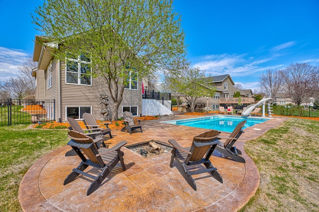 view of pool featuring an outdoor fire pit, a water slide, stairway, a fenced backyard, and a patio