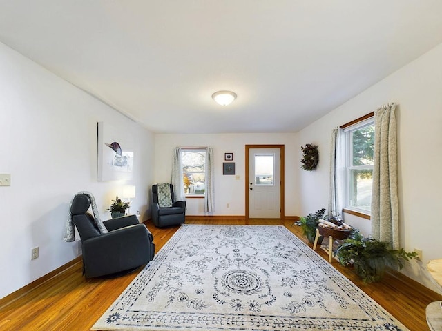 living area with baseboards and wood finished floors