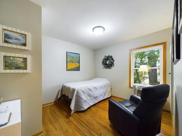bedroom with baseboards and wood finished floors