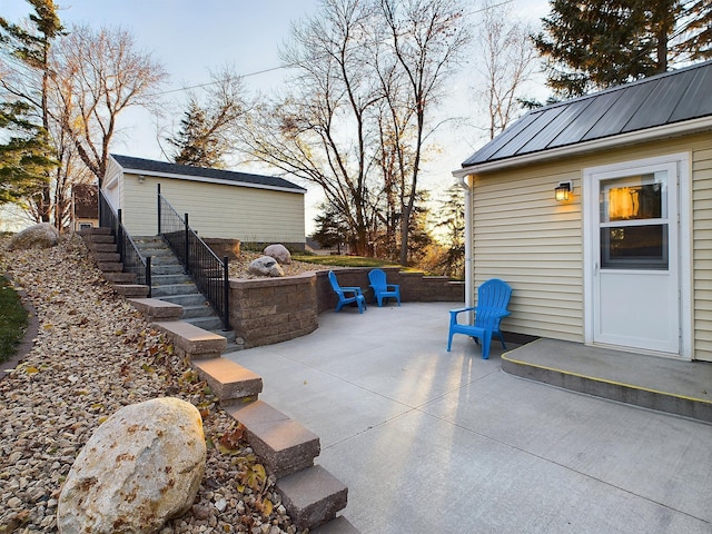 view of patio / terrace with stairs and an outbuilding