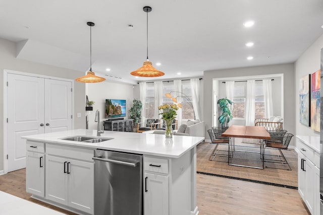 kitchen with light wood finished floors, dishwasher, a sink, and recessed lighting