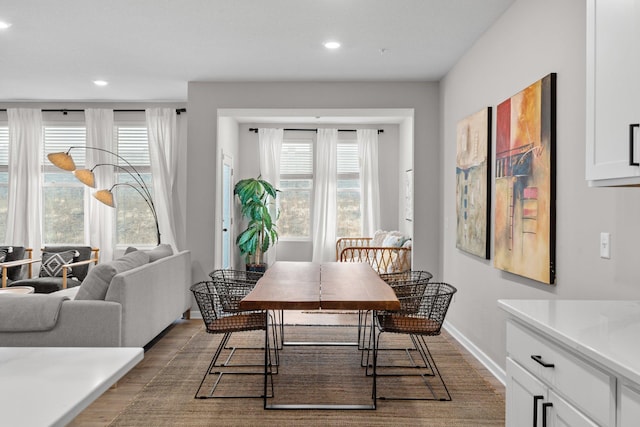 dining space with recessed lighting, plenty of natural light, baseboards, and wood finished floors