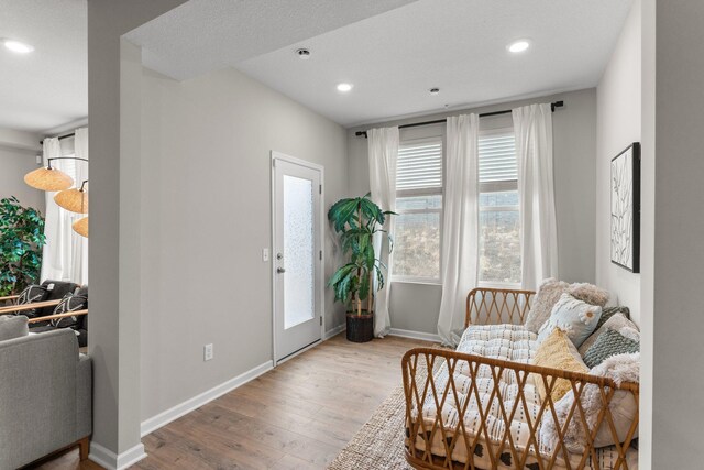 living area featuring recessed lighting, baseboards, and wood finished floors
