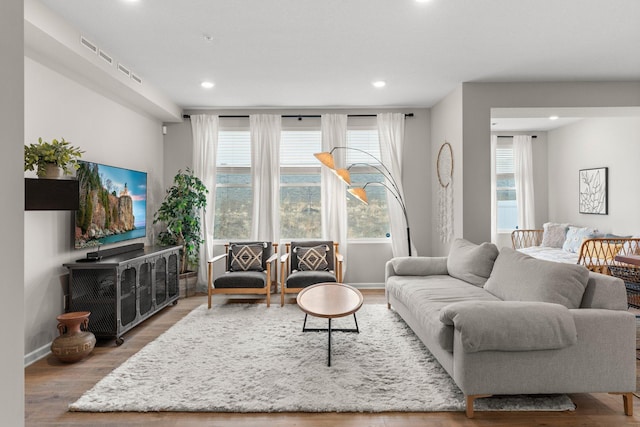 living room with recessed lighting, baseboards, and wood finished floors