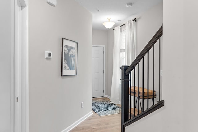 foyer featuring stairway, light wood-type flooring, and baseboards