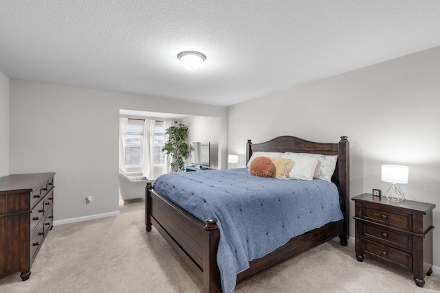 bedroom with baseboards, light carpet, and a textured ceiling