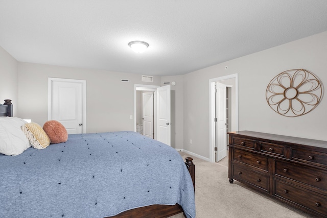 bedroom with visible vents, light colored carpet, and baseboards