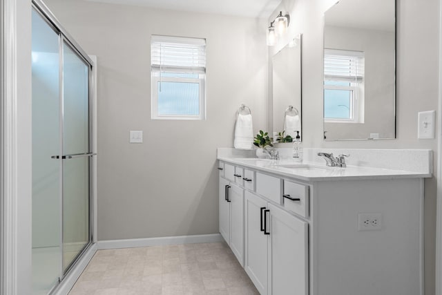 full bath featuring a sink, a shower with shower door, and a healthy amount of sunlight