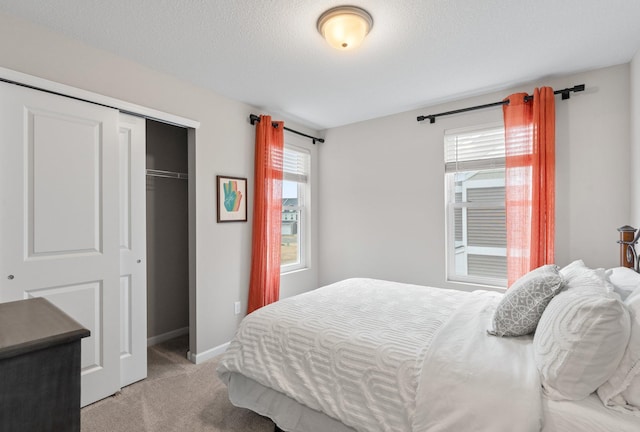 bedroom featuring a closet, light colored carpet, and baseboards