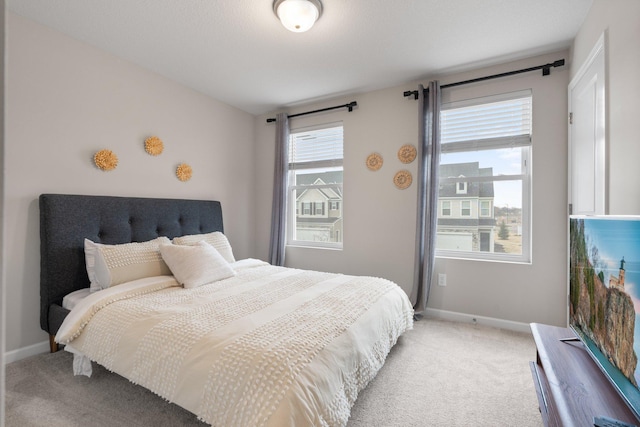 bedroom featuring light carpet and baseboards