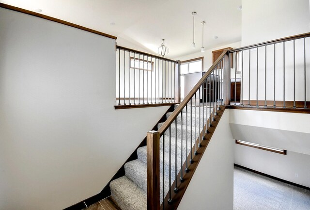 stairs featuring vaulted ceiling and baseboards