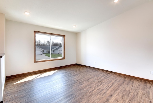spare room featuring recessed lighting, wood finished floors, and baseboards