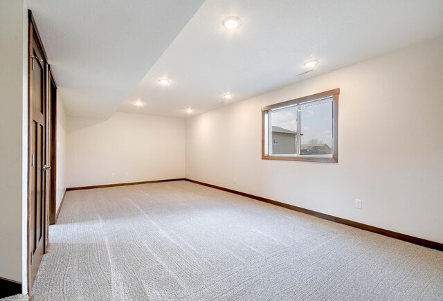 empty room featuring recessed lighting, baseboards, and light colored carpet
