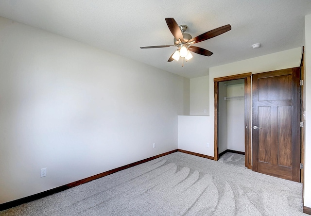 unfurnished bedroom featuring ceiling fan, baseboards, carpet flooring, and a closet